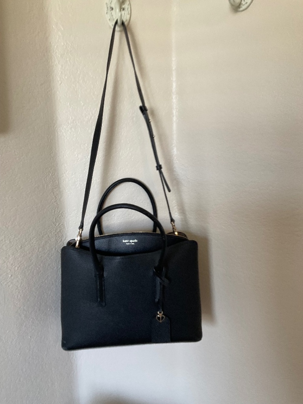 Kate Spade New York , black leather satchel with shoulder strap.